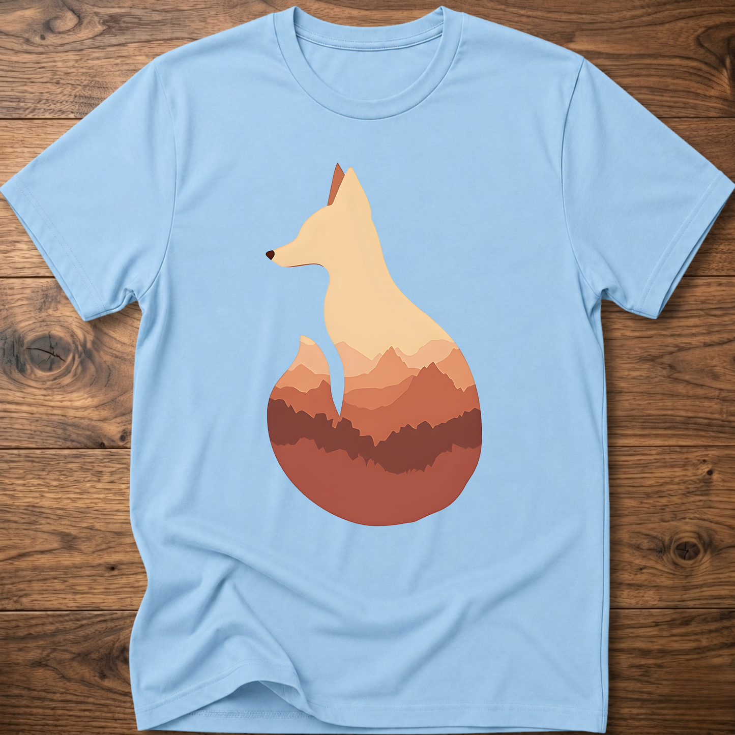 Light blue t-shirt with cream fox silhouette graphic over sunset mountains