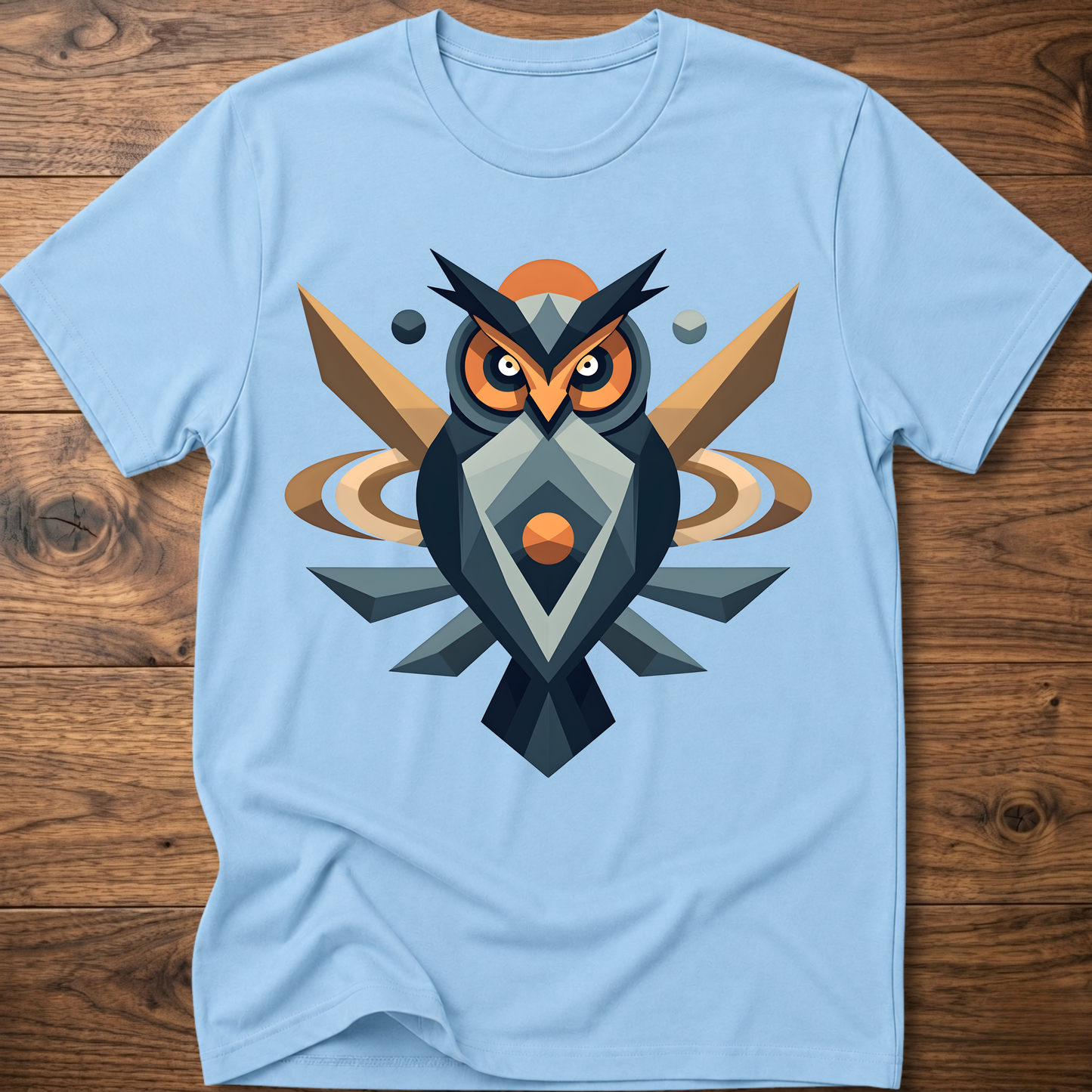 Light blue t-shirt with geometric owl graphic in dark blue, tan, and orange.