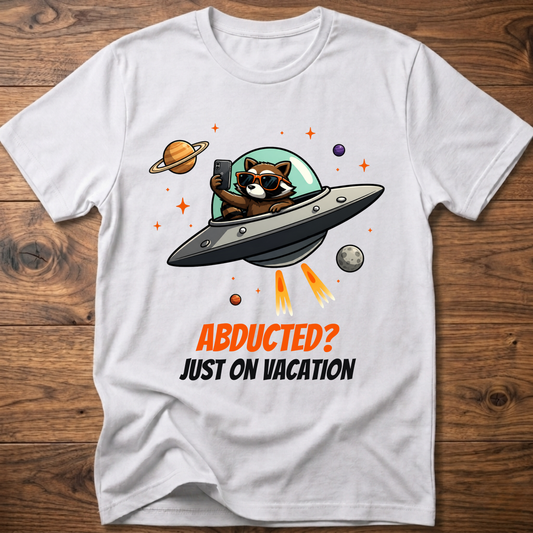 White t-shirt with space raccoon graphic and “Abducted? Just on Vacation” text
