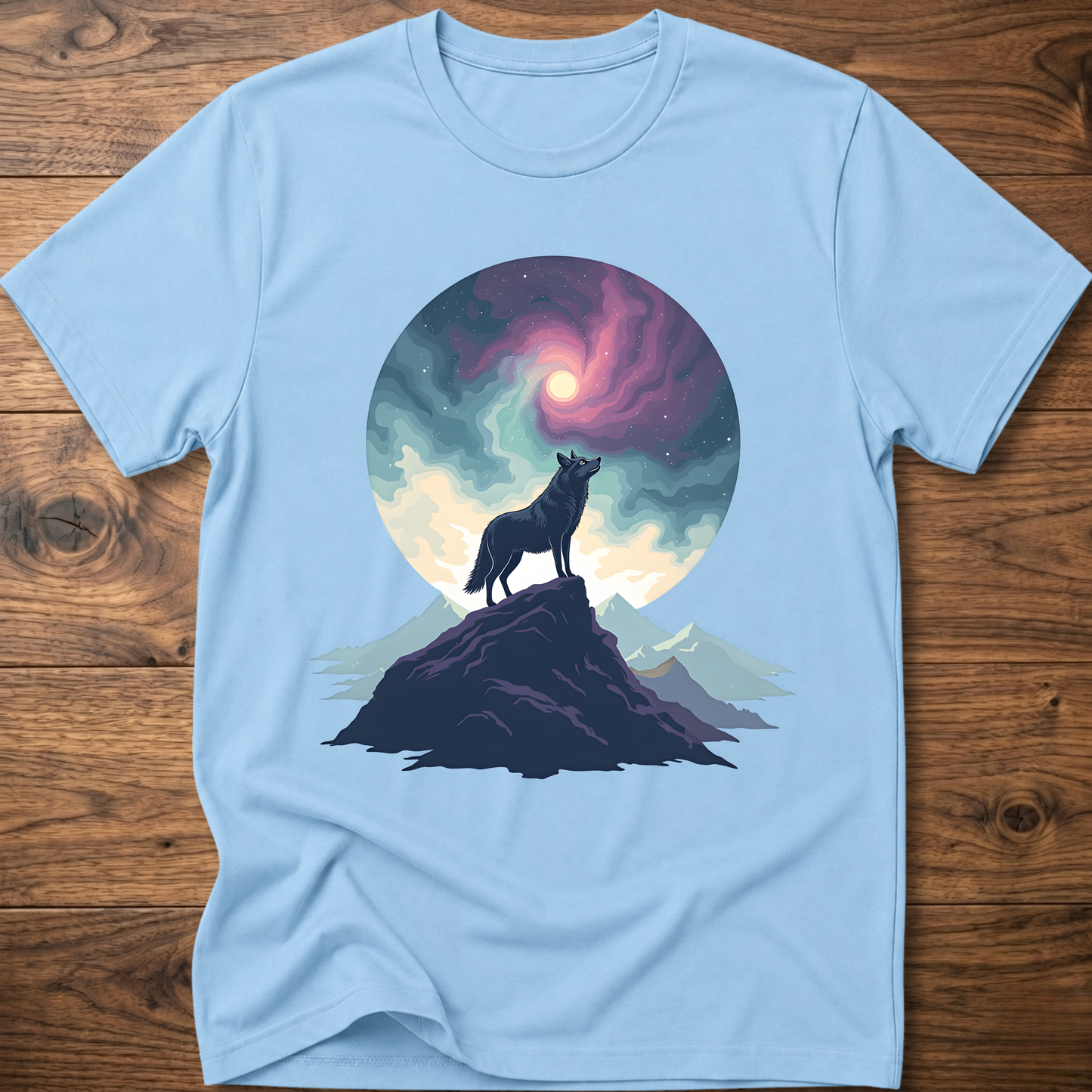Light blue graphic t-shirt with wolf silhouette on mountain under glowing moon circle