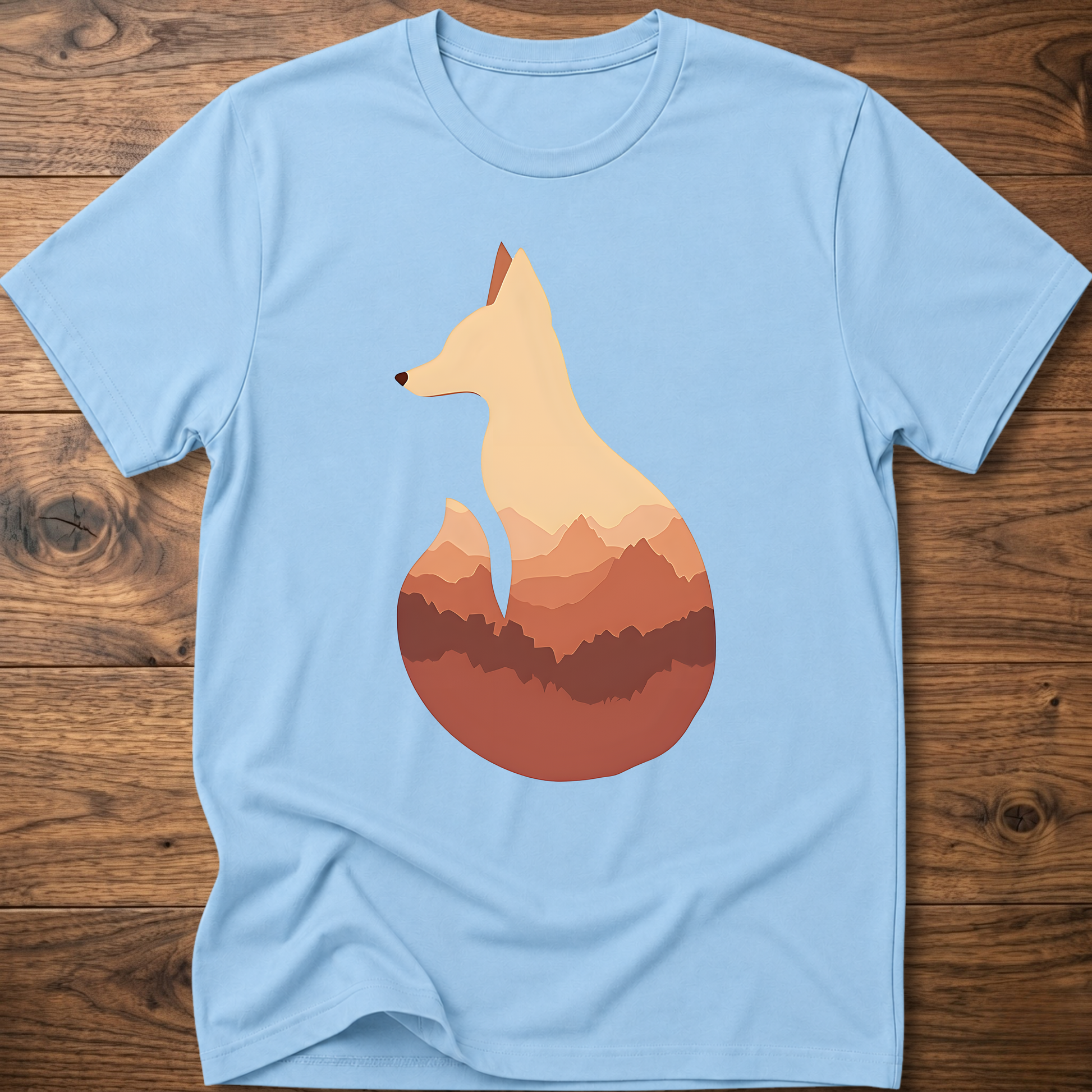 Light blue t-shirt with cream fox silhouette graphic over sunset mountains