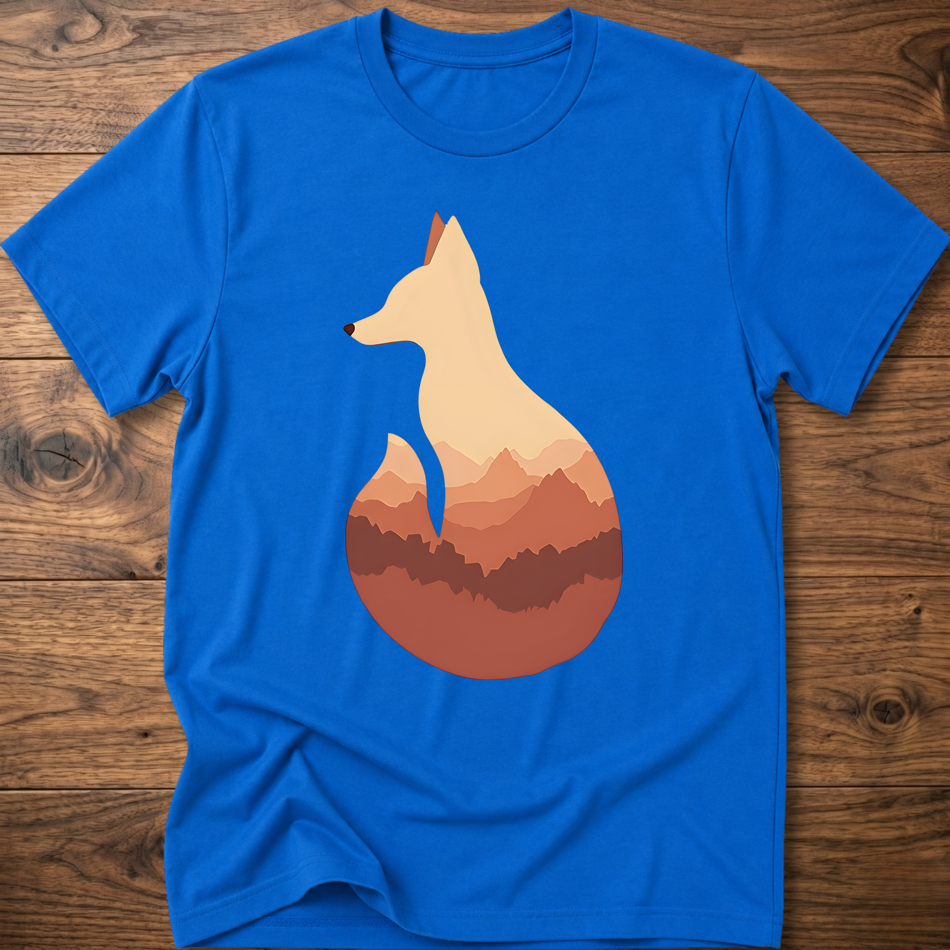 Royal blue t-shirt with cream fox silhouette graphic over sunset mountains