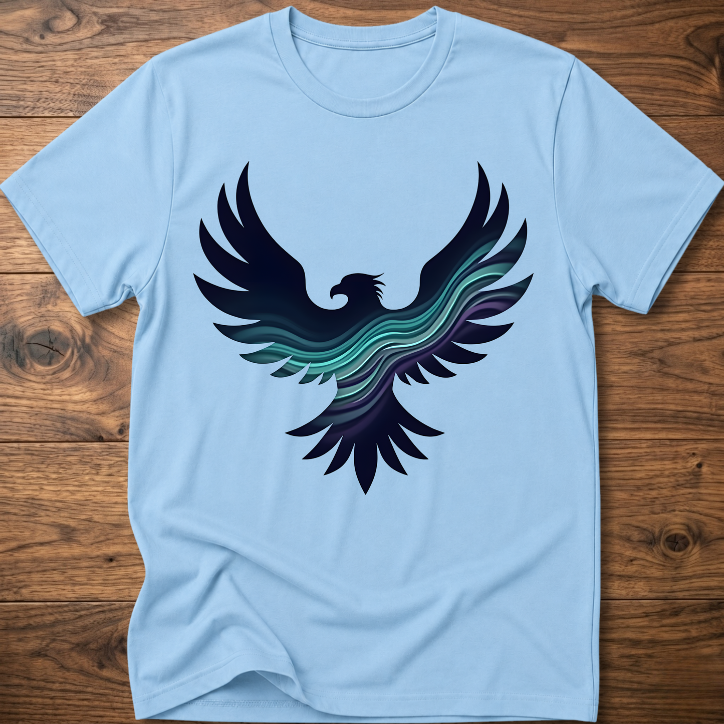 Light blue crew-neck T-shirt with large phoenix-style eagle graphic in navy and teal