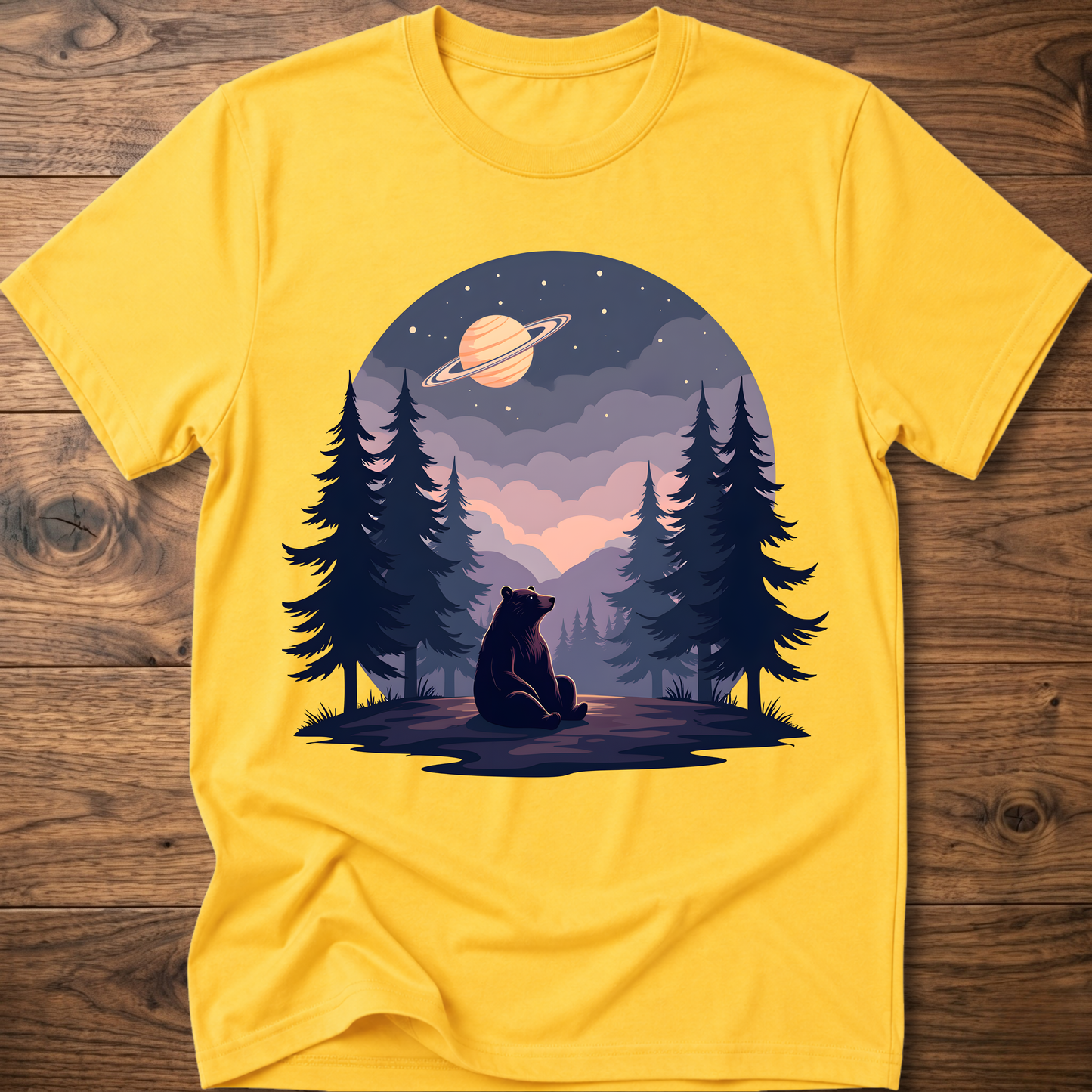 Yellow t-shirt with night sky bear graphic, ringed planet and pine trees on front