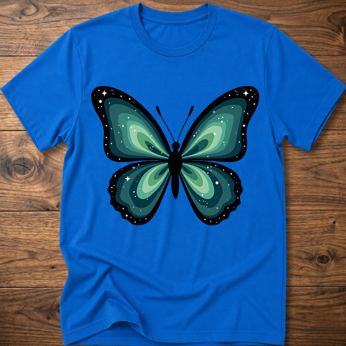 Royal blue t-shirt with teal butterfly graphic in navy outline, crew neck.