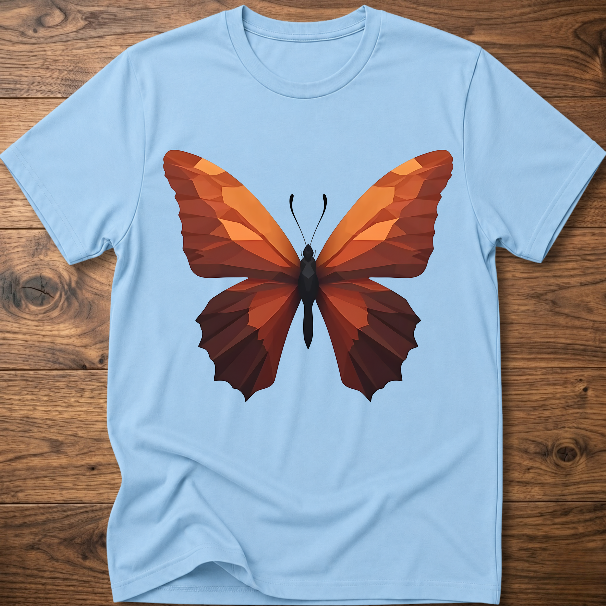 Light blue T-shirt with geometric butterfly graphic, orange and brown wings on front.