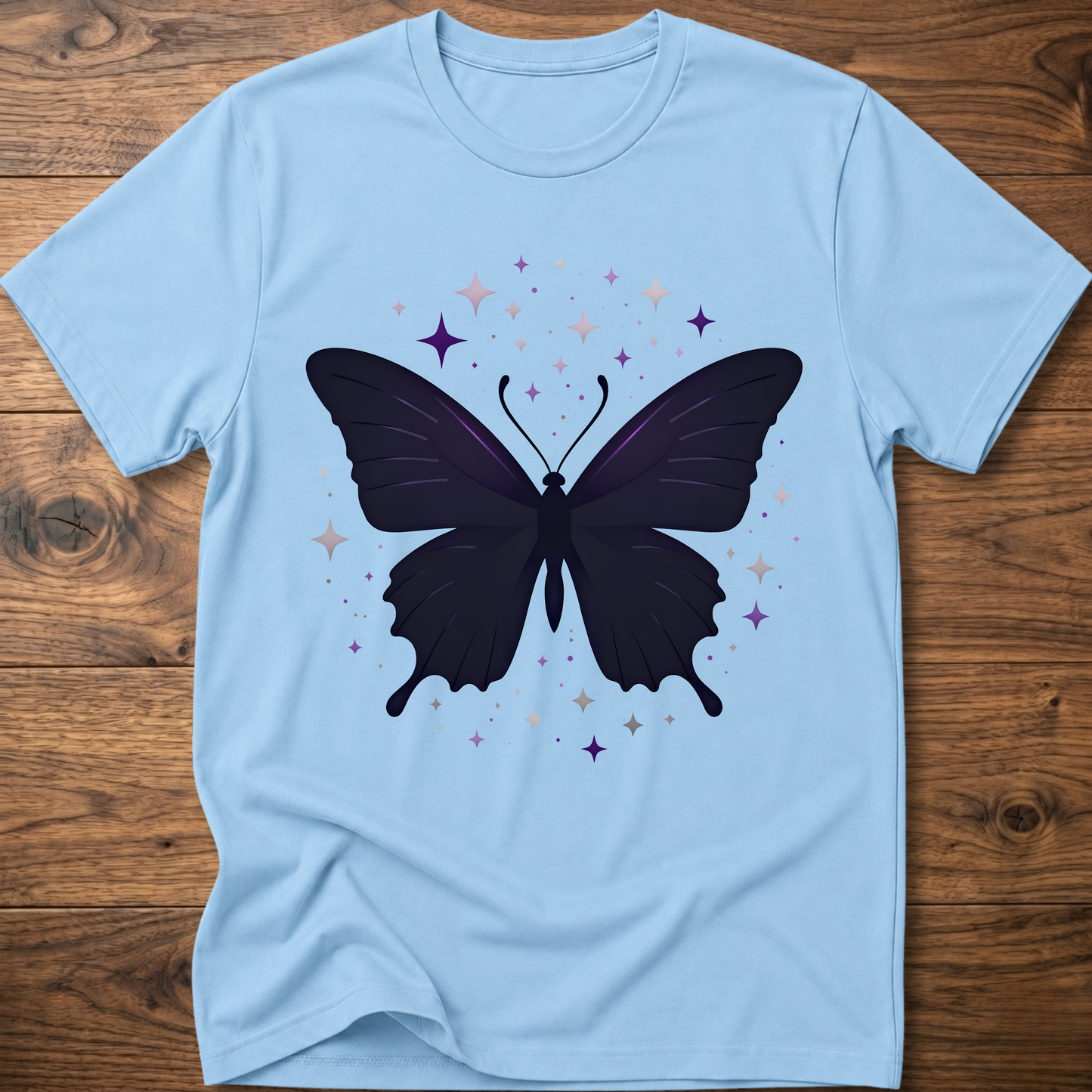 Light blue T-shirt with dark butterfly star graphic in purple and gray