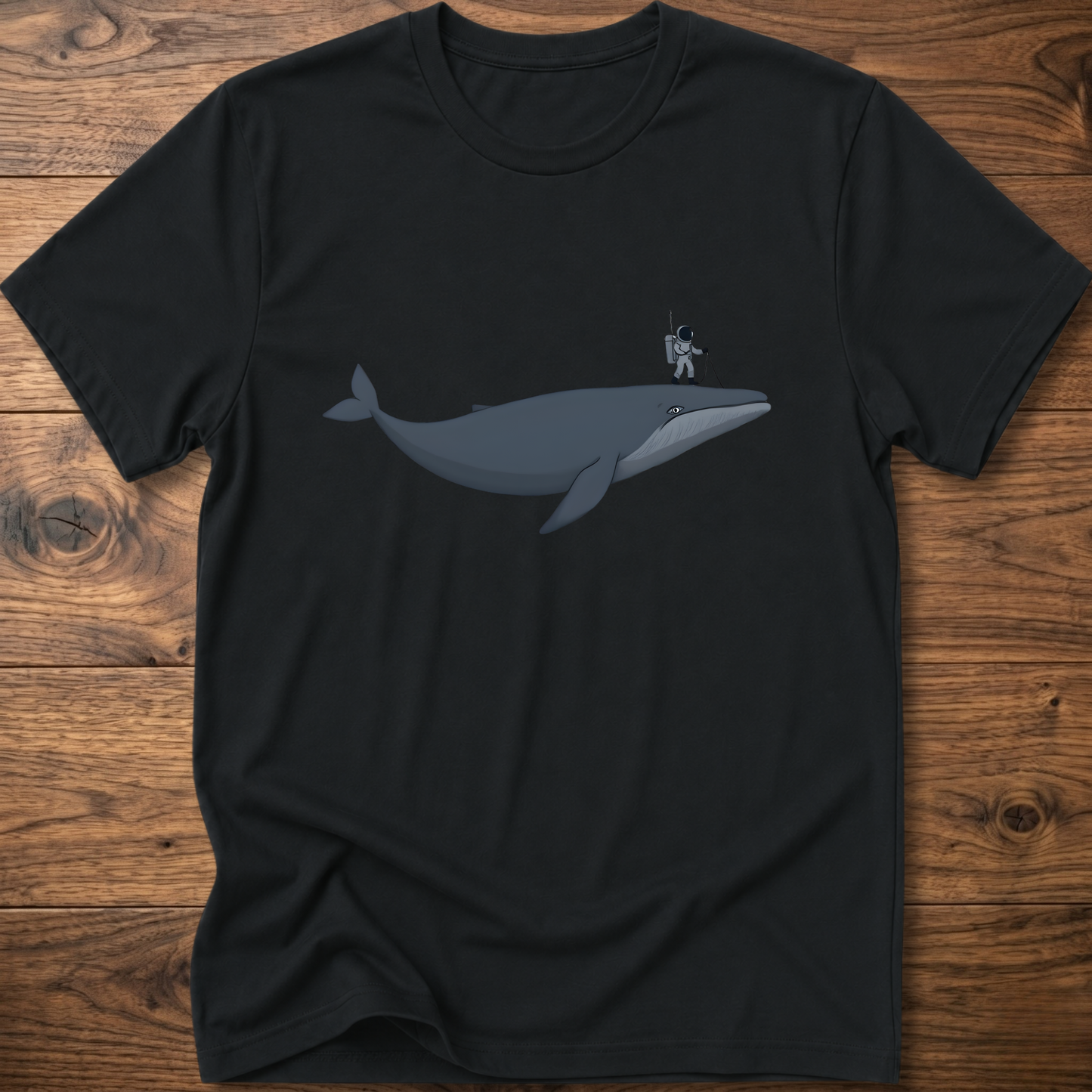 Black astronaut whale T-shirt with graphic whale and astronaut standing on back fin