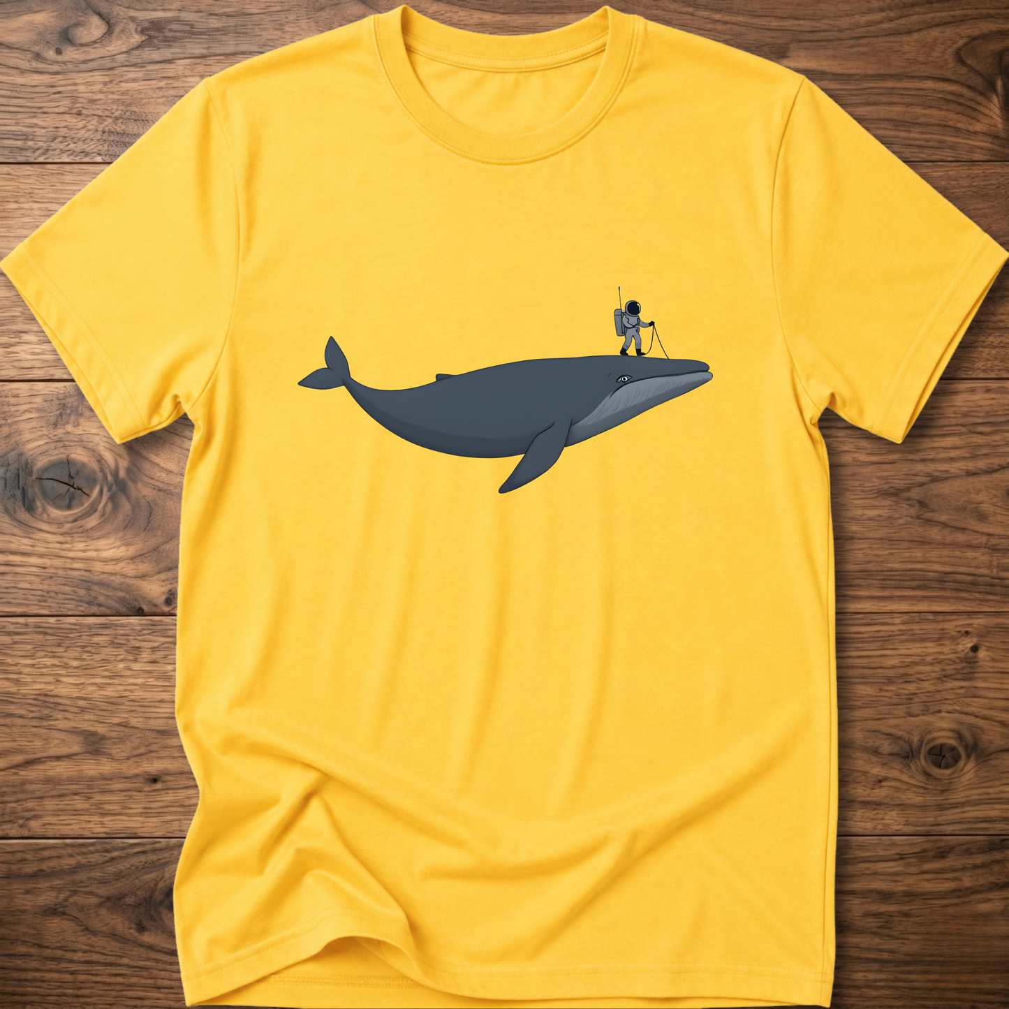 Yellow astronaut whale T-shirt with graphic whale and astronaut standing on back fin