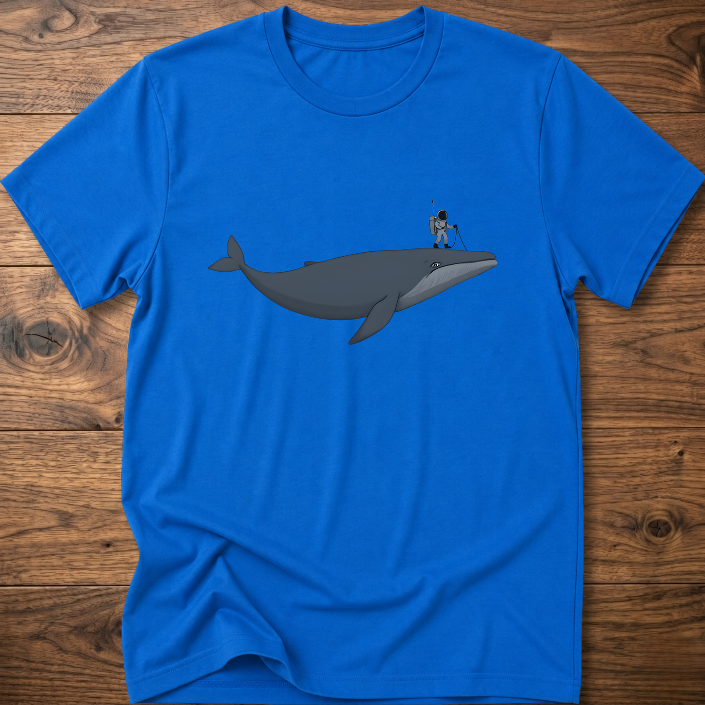 Blue astronaut whale T-shirt with graphic whale and astronaut standing on back fin
