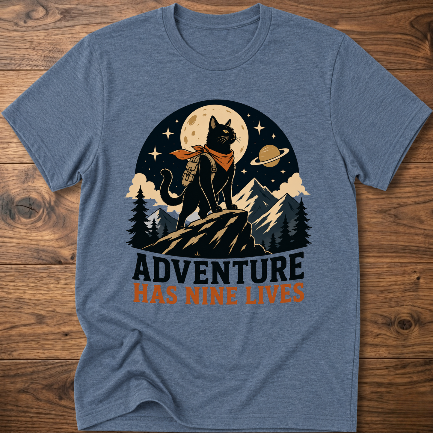 Heather blue cat graphic t-shirt, moonlit cat on mountains with 'Adventure Has Nine Lives'