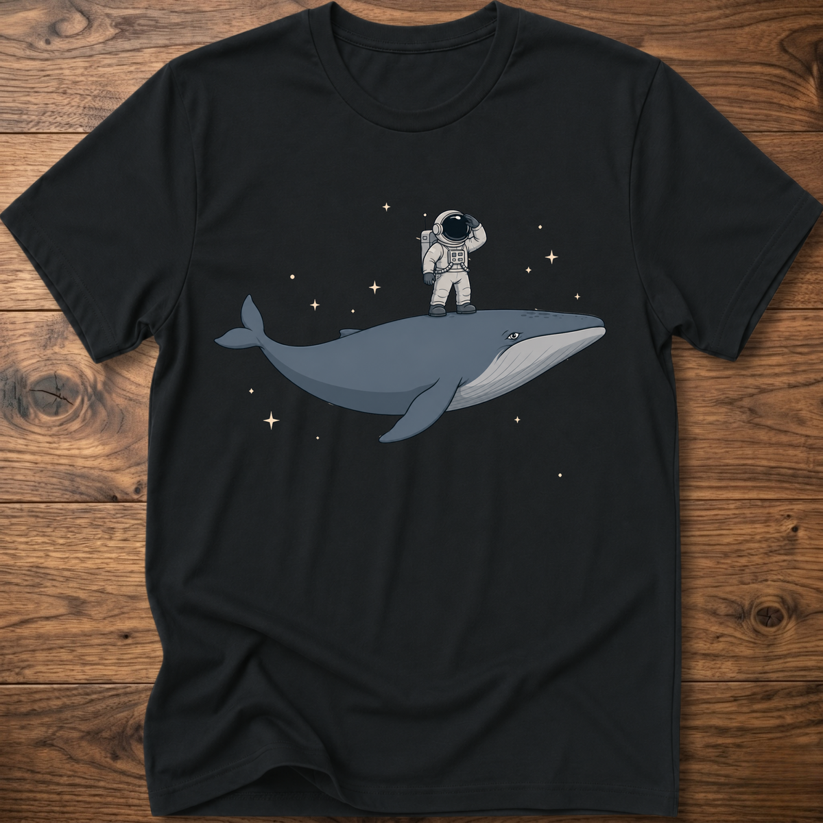 Black short-sleeve t-shirt with astronaut riding a whale graphic and star accents