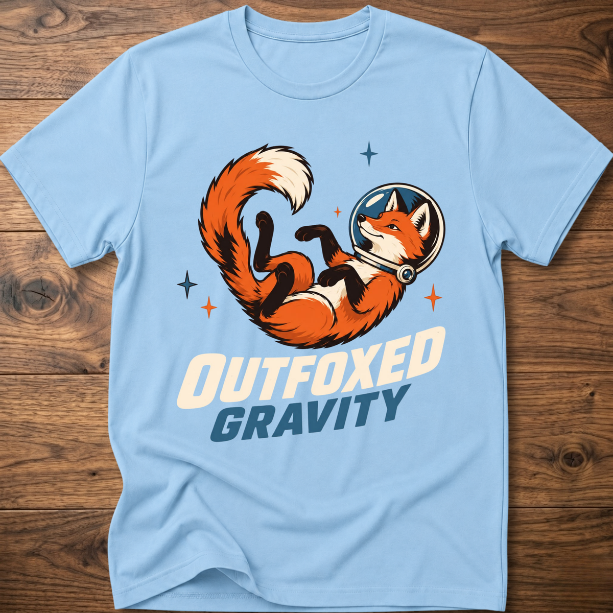 Outfoxed Gravity T-shirt in light blue with orange fox gravity graphic and logo text