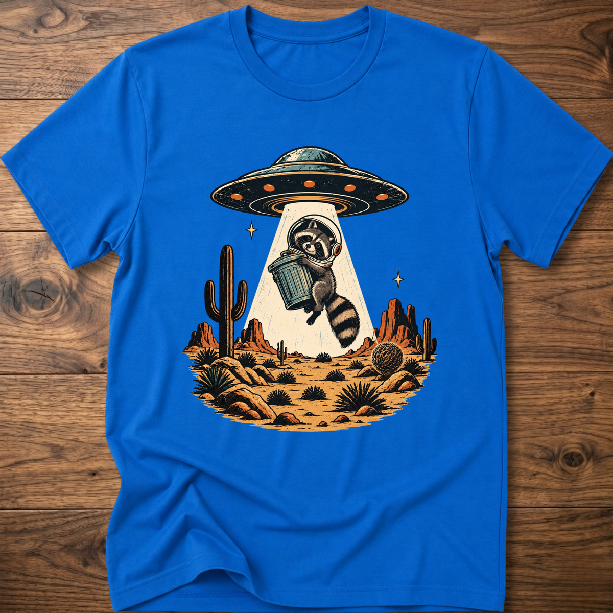 Royal blue crew-neck T-shirt with astronaut raccoon graphic, UFO, and desert cactus