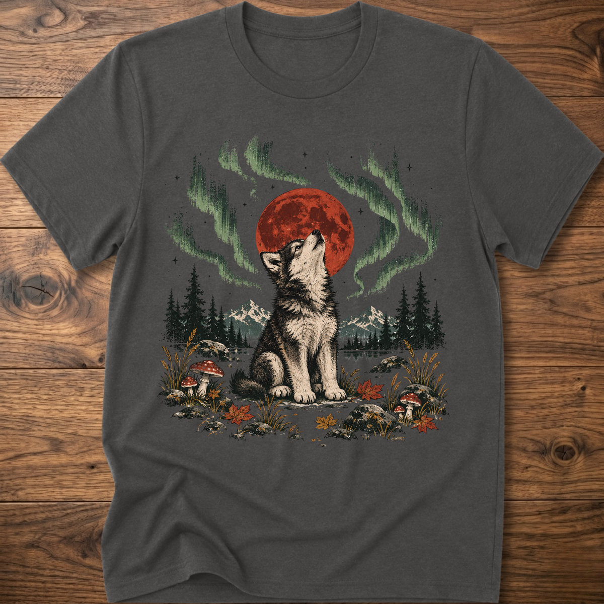 Charcoal t-shirt with seated wolf and red moon, green aurora landscape graphic.