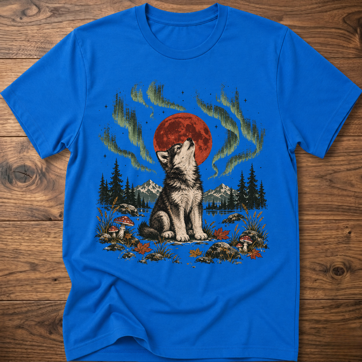 Royal blue t-shirt with seated wolf, red moon, green aurora forest scene print.