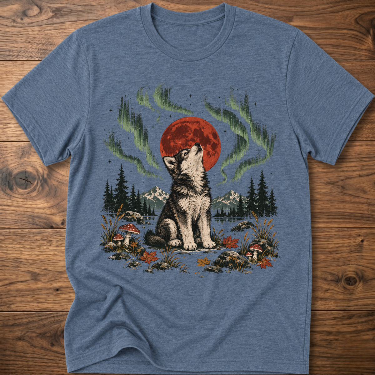 Heather indigo t-shirt with seated wolf and red moon, green aurora trees scene.