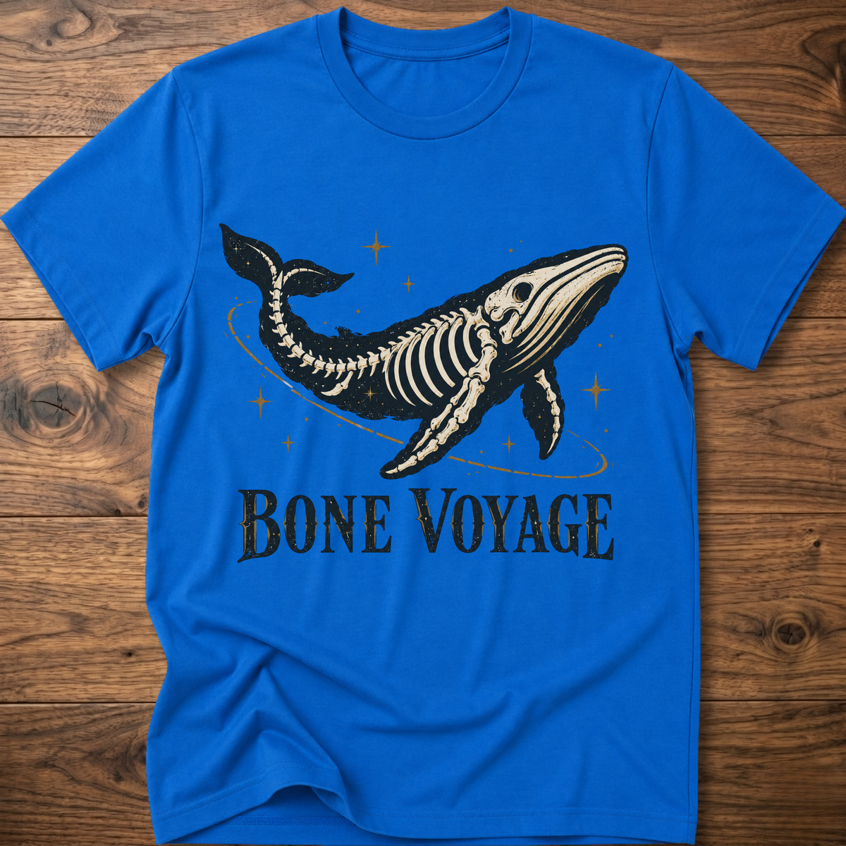 Royal blue whale graphic t-shirt with 'Bone Voyage' text and skeleton whale front print