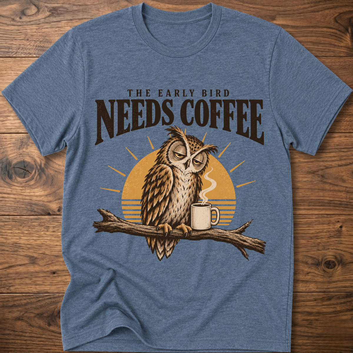 Blue crew-neck T-shirt with owl perched on a branch beside a coffee mug graphic