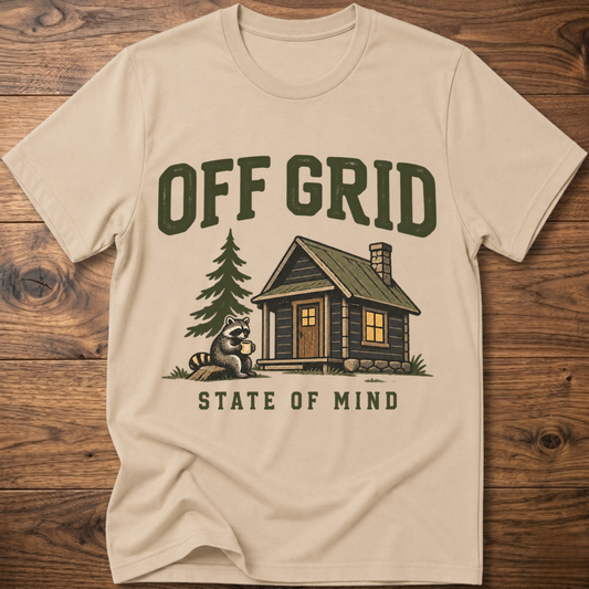 Sand T-shirt with “Off Grid” graphic, house, pine tree, and raccoon
