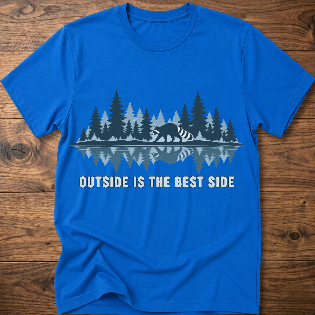 Bright blue crew-neck T-shirt with blue raccoon tree scene graphic and “OUTSIDE IS THE BEST SIDE” text