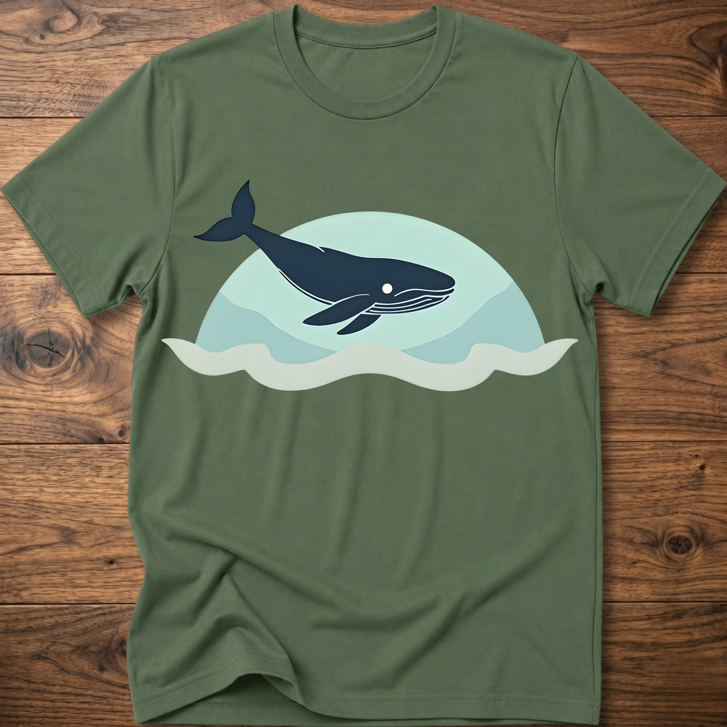 Military green crew-neck t-shirt with dark whale graphic over teal waves design