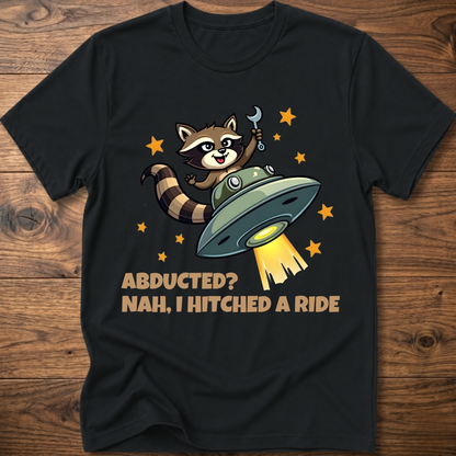 Black raccoon UFO graphic T-shirt with 'ABDUCTED?' and 'HITCHED A RIDE' text
