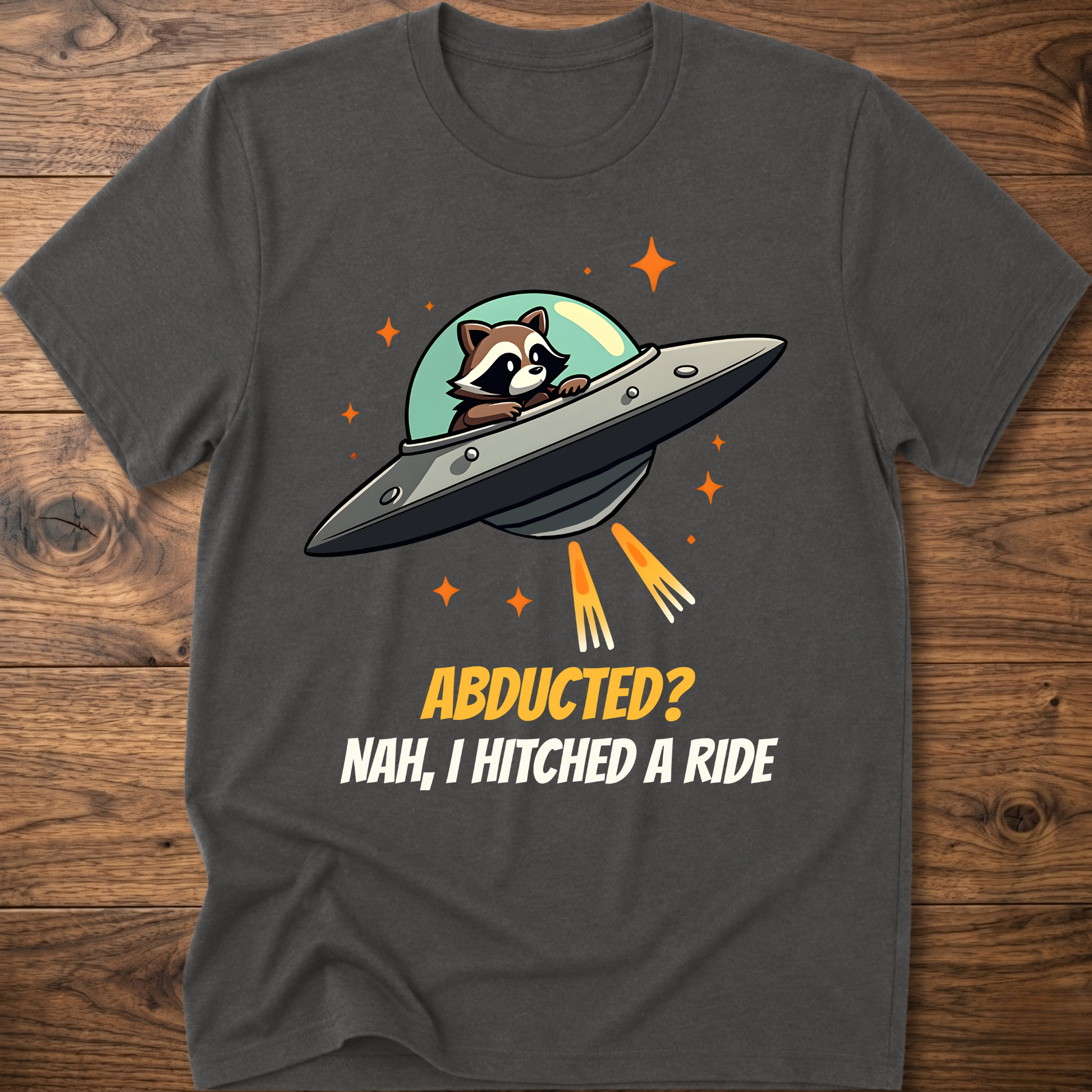 Charcoal raccoon graphic t-shirt with UFO and orange "ABDUCTED?" text
