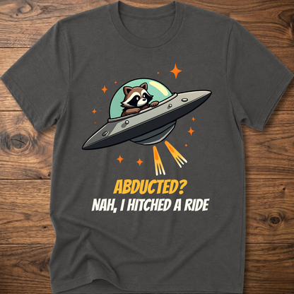 Charcoal raccoon graphic t-shirt with UFO and orange "ABDUCTED?" text
