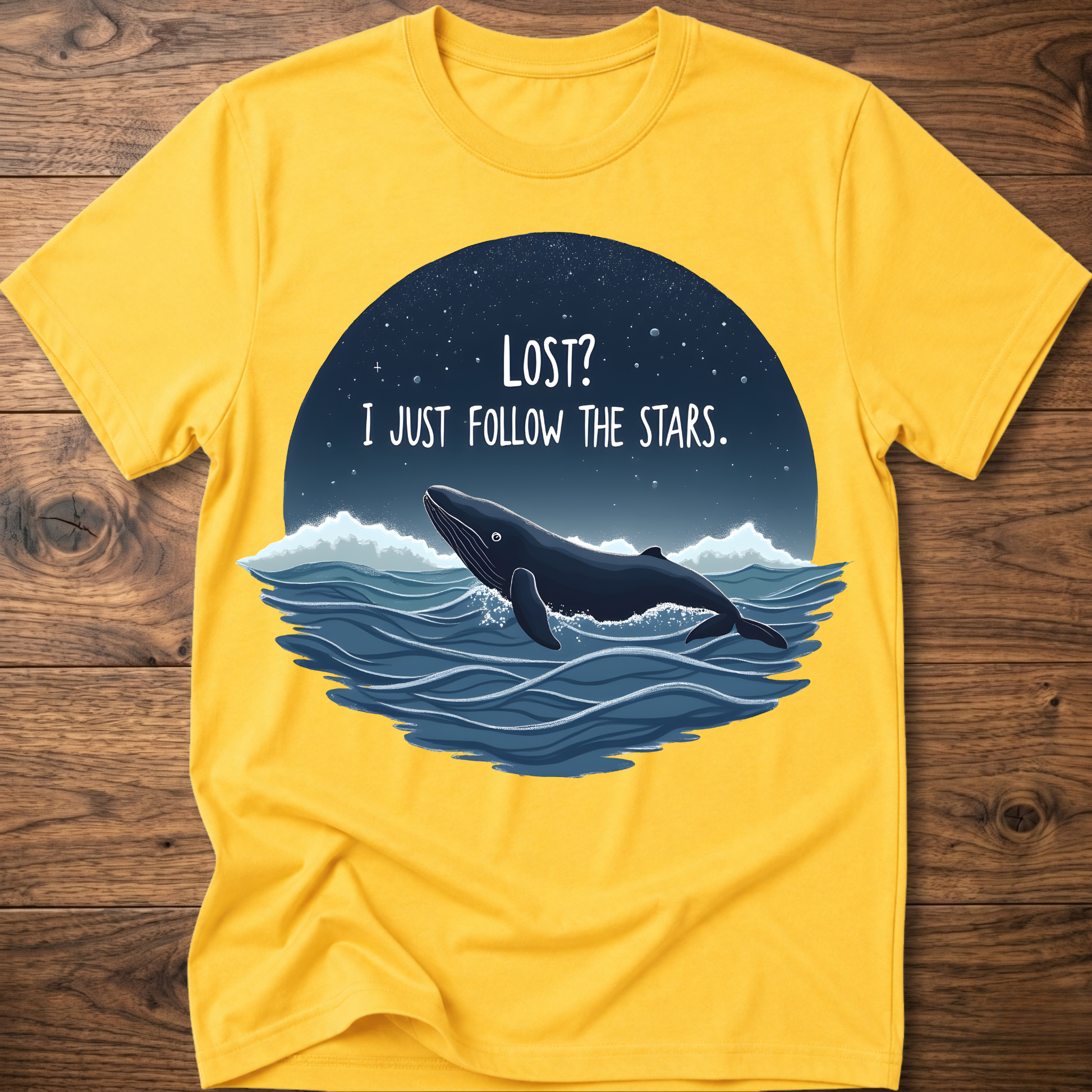 Yellow whale graphic t-shirt with circular “LOST? I JUST FOLLOW THE STARS.” print