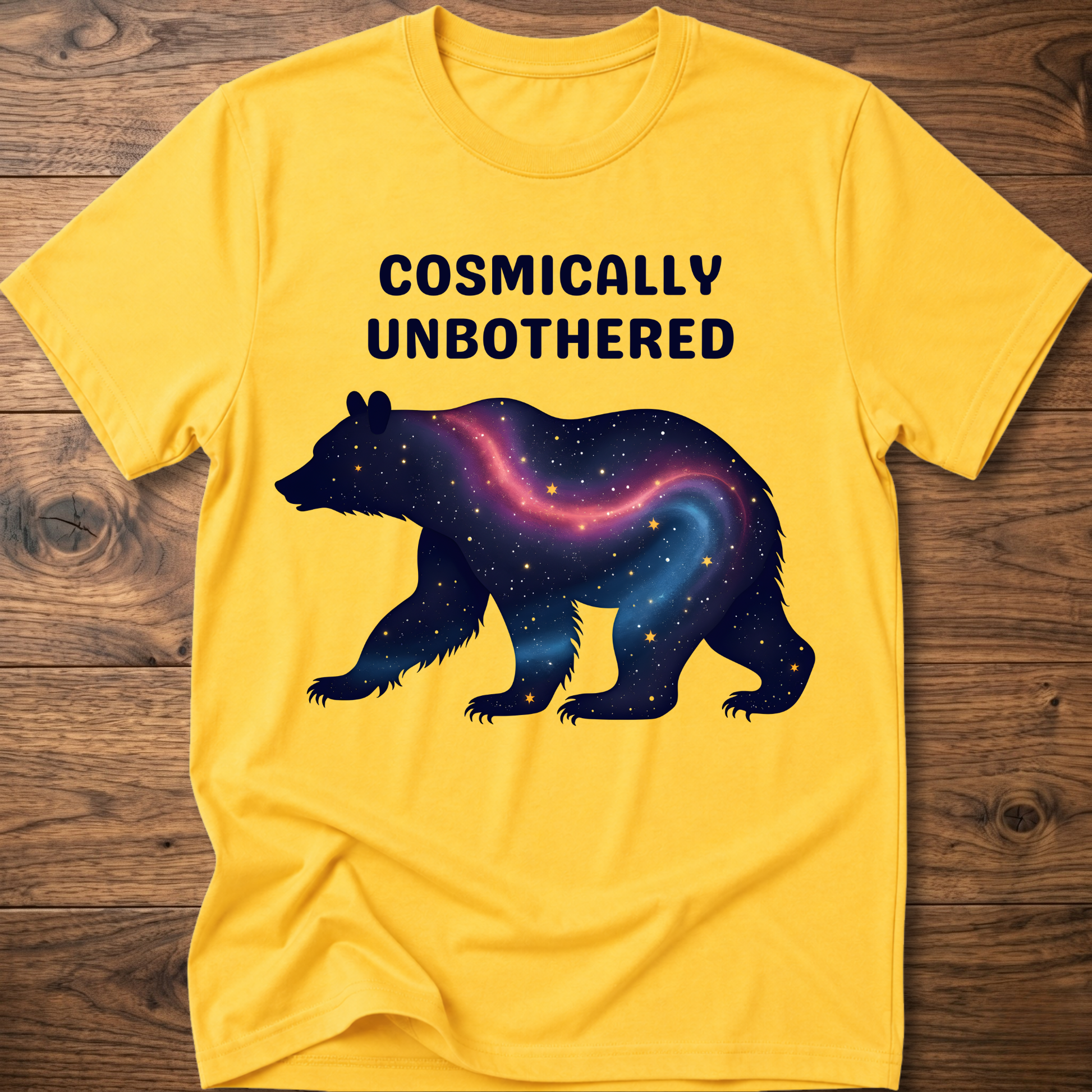 Yellow graphic t-shirt with cosmic bear and COSMICALLY UNBOTHERED text