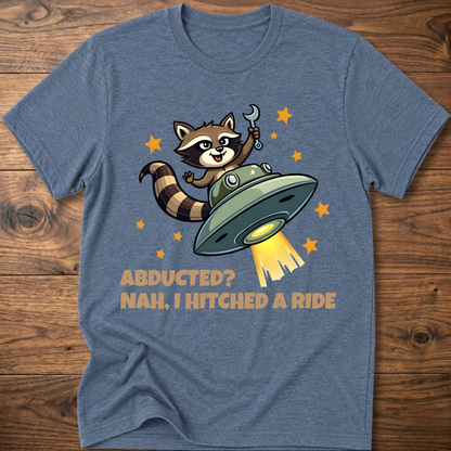 Light blue raccoon UFO graphic T-shirt with 'ABDUCTED?' and 'HITCHED A RIDE' text