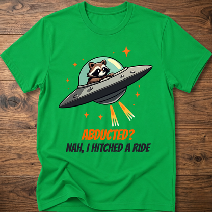 Green raccoon graphic t-shirt with UFO and orange "ABDUCTED?" text
