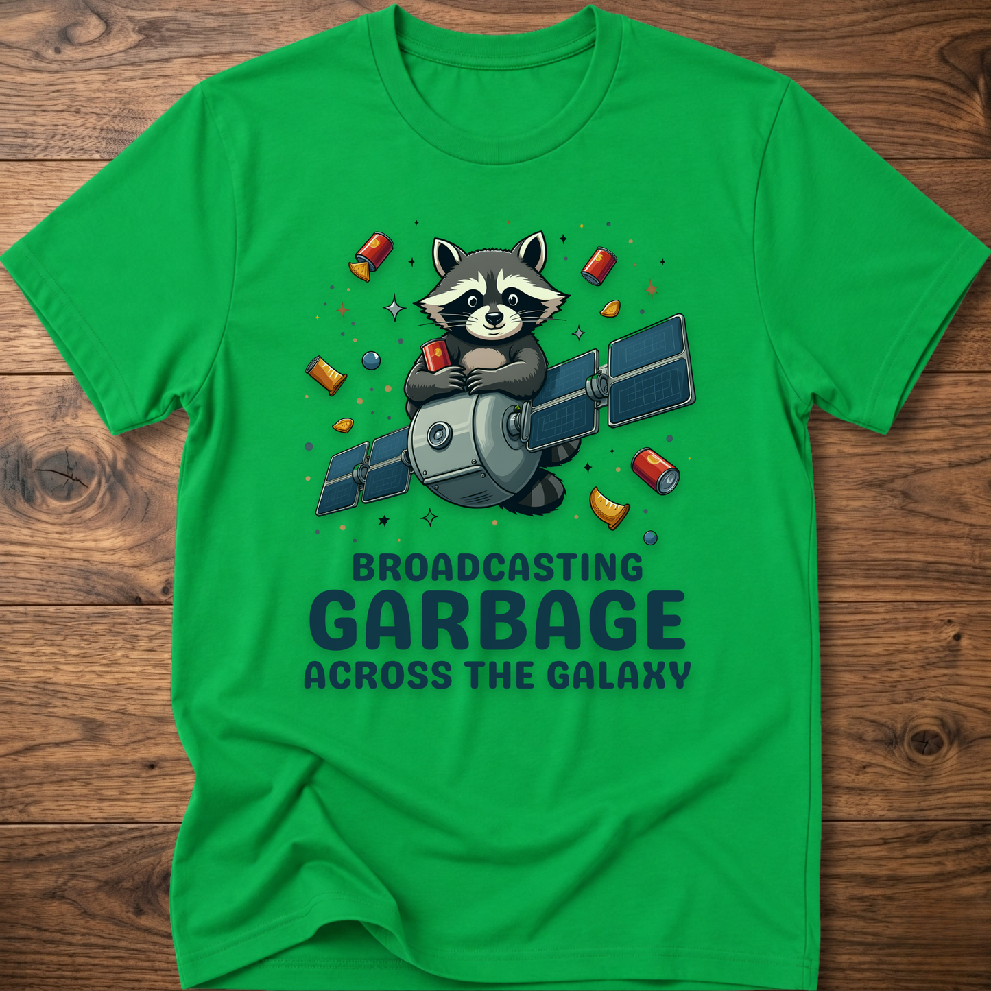 Green crew-neck T-shirt with raccoon holding megaphone graphic and “Broadcasting Garbage” text.
