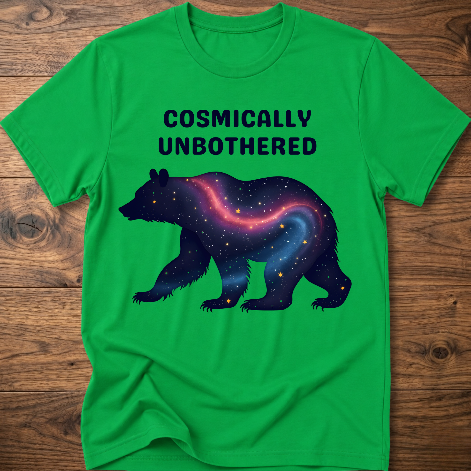 Green graphic t-shirt with cosmic bear and COSMICALLY UNBOTHERED lettering