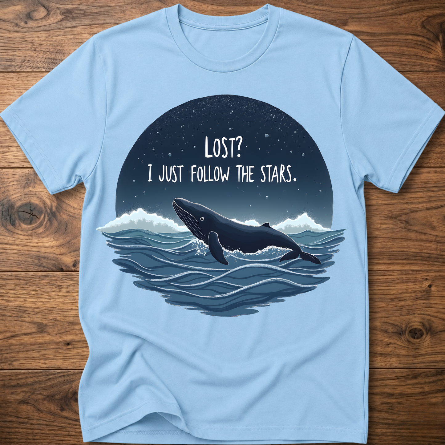 Light blue whale graphic t-shirt with circular “LOST? I JUST FOLLOW THE STARS.” print