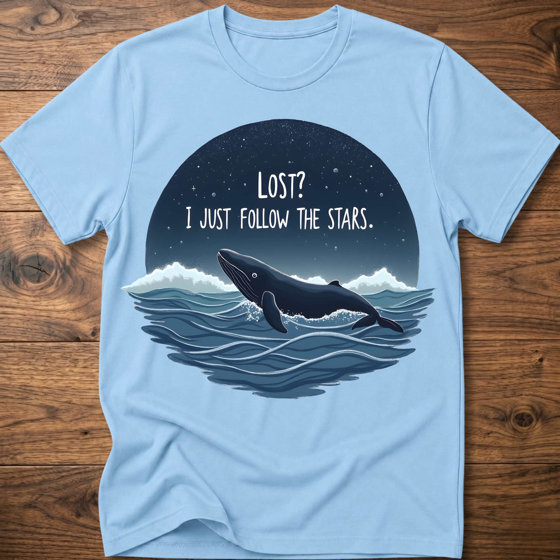 Light blue whale graphic t-shirt with circular “LOST? I JUST FOLLOW THE STARS.” print