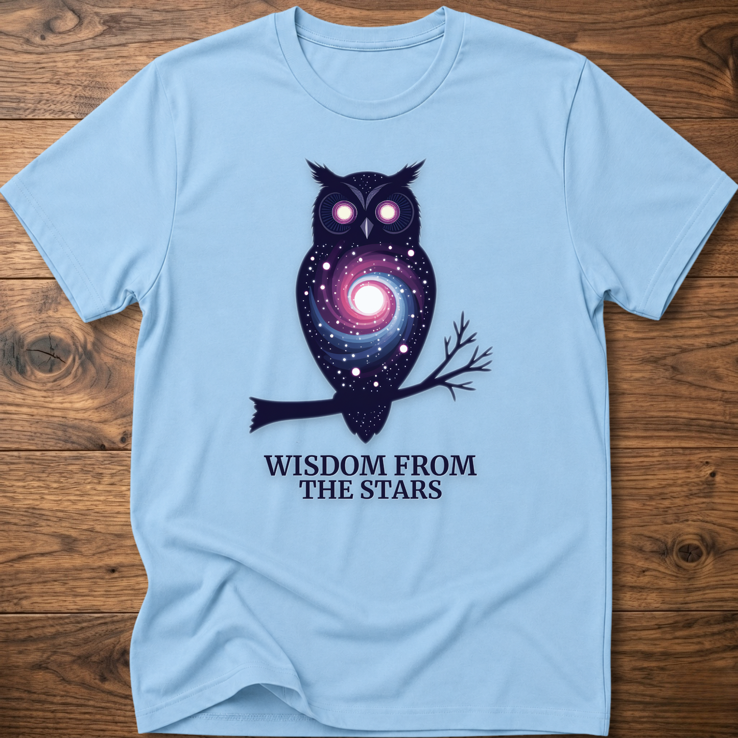 Light blue t-shirt with owl nebula graphic and “Wisdom from the Stars” text
