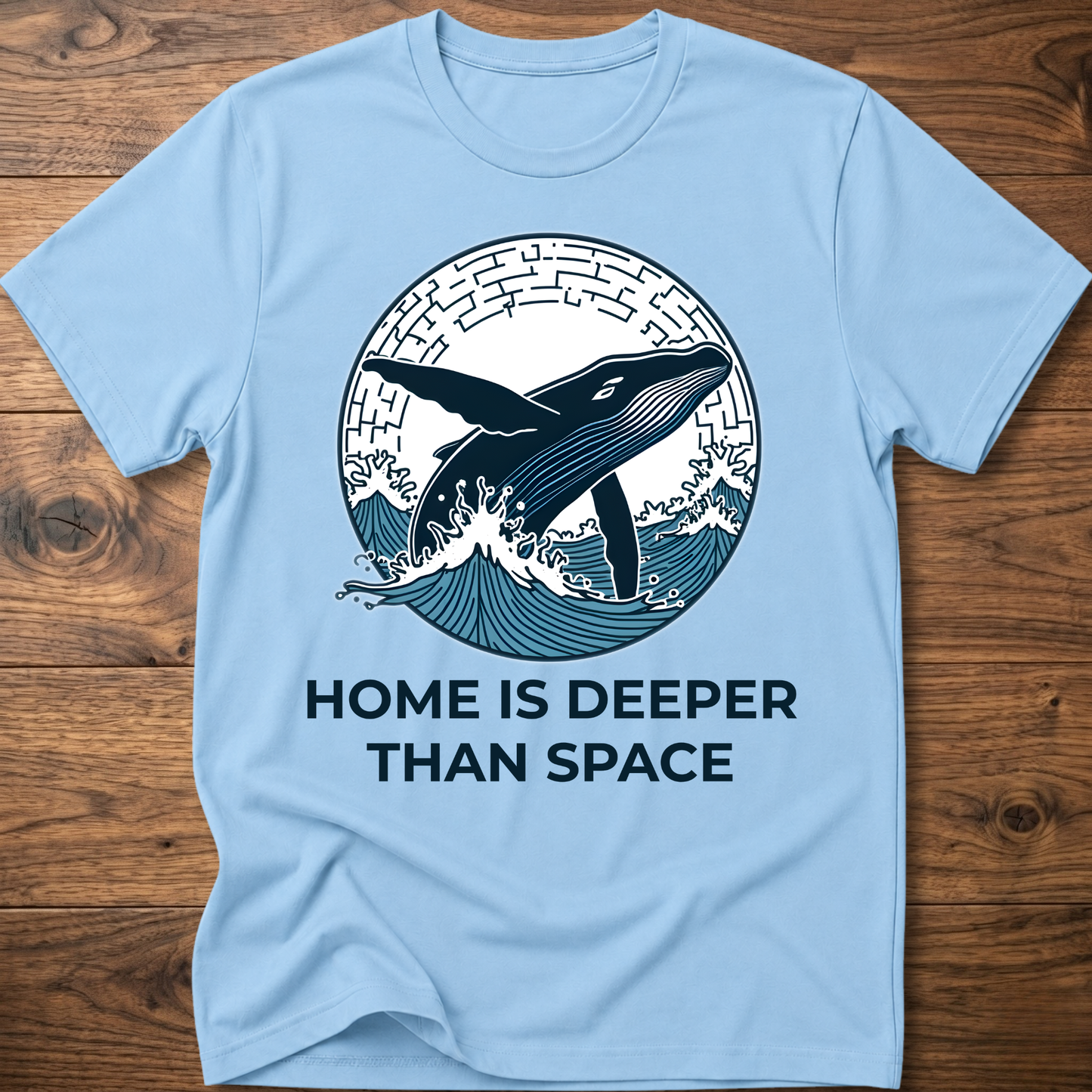 Light blue T-shirt with whale surf graphic and “HOME IS DEEPER THAN SPACE” text