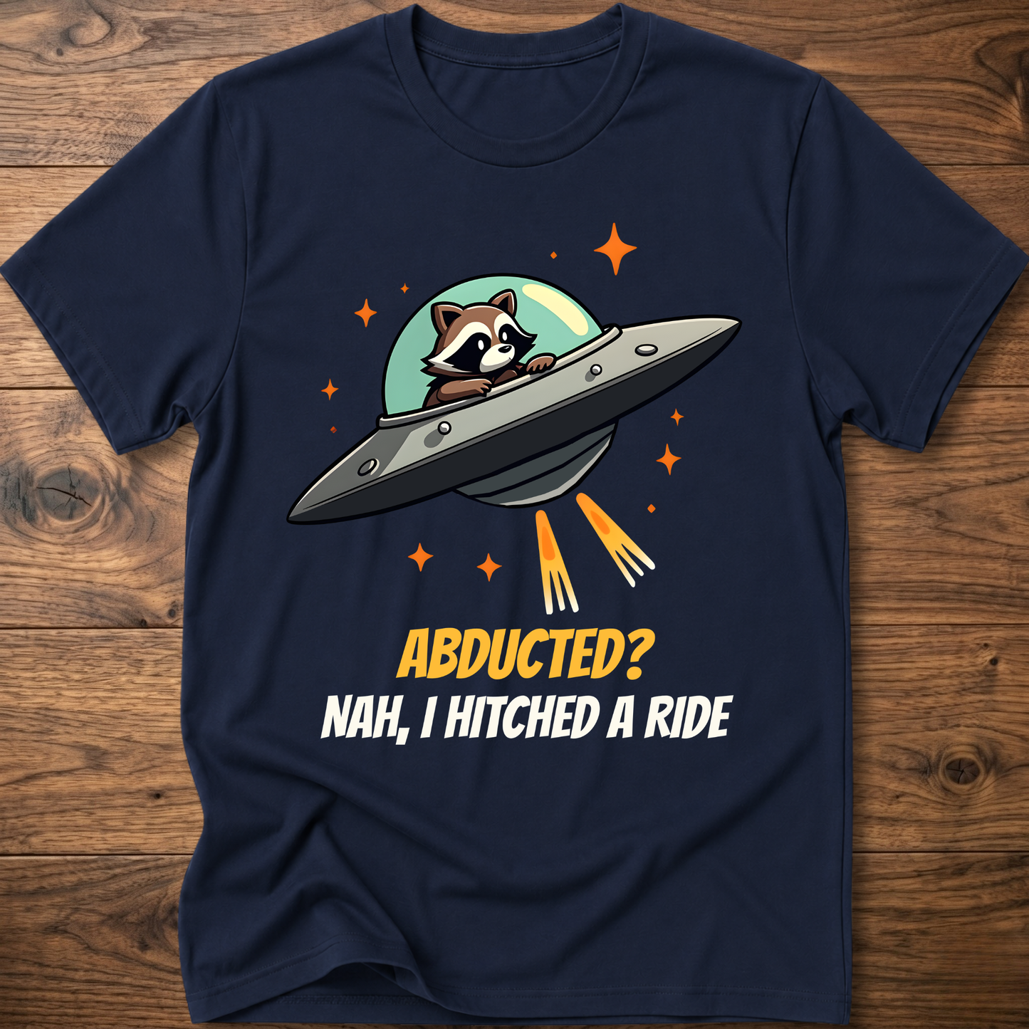 Navy raccoon graphic t-shirt with UFO and orange "ABDUCTED?" text