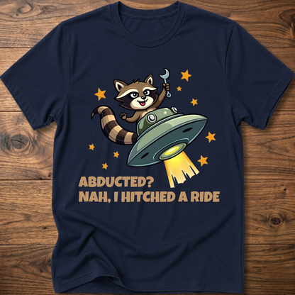 Navy raccoon UFO graphic T-shirt with 'ABDUCTED?' and 'HITCHED A RIDE' text