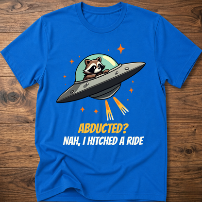 Royal blue raccoon graphic t-shirt with UFO and orange "ABDUCTED?" text