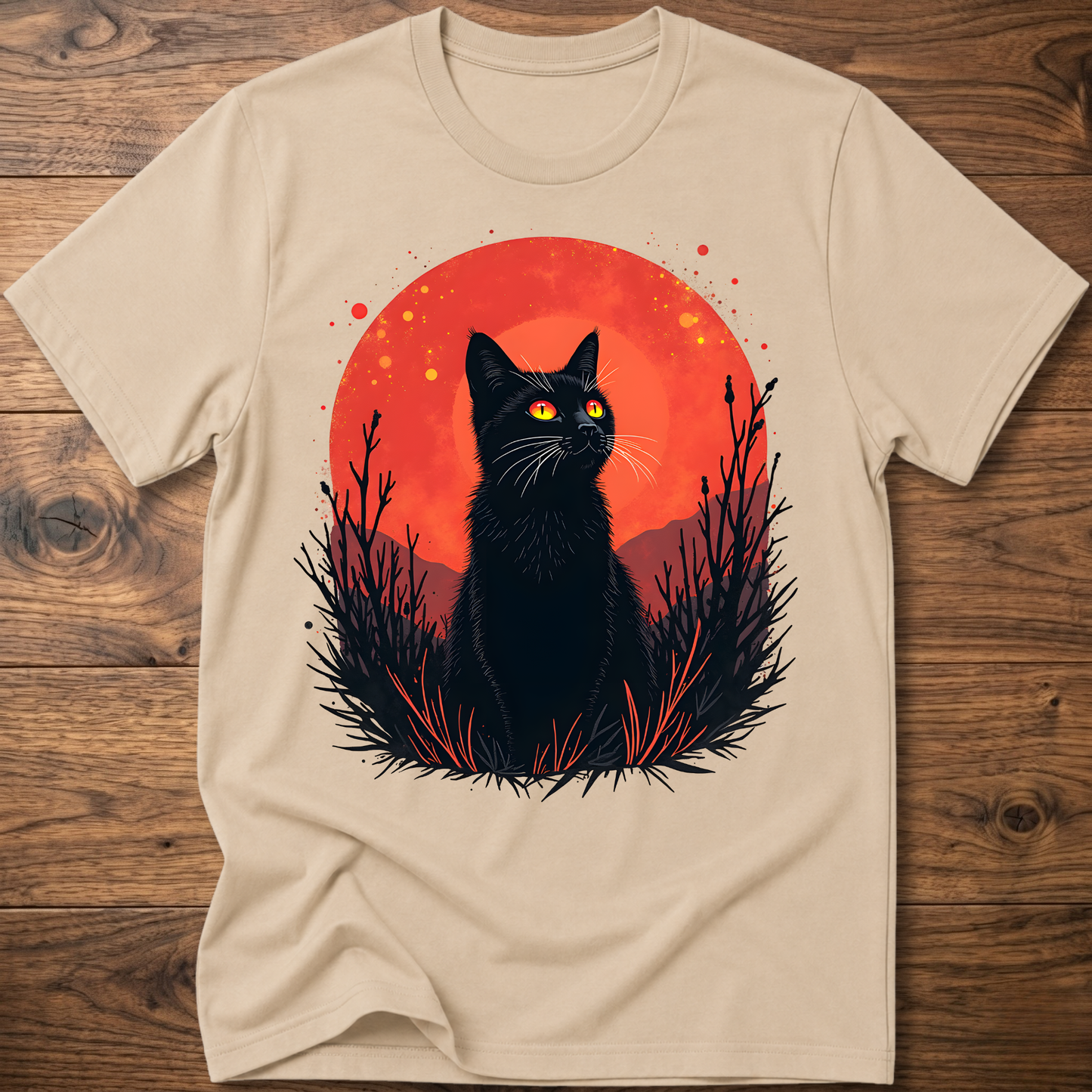 Beige T-shirt with black cat graphic in red-orange halo and night-plant silhouettes