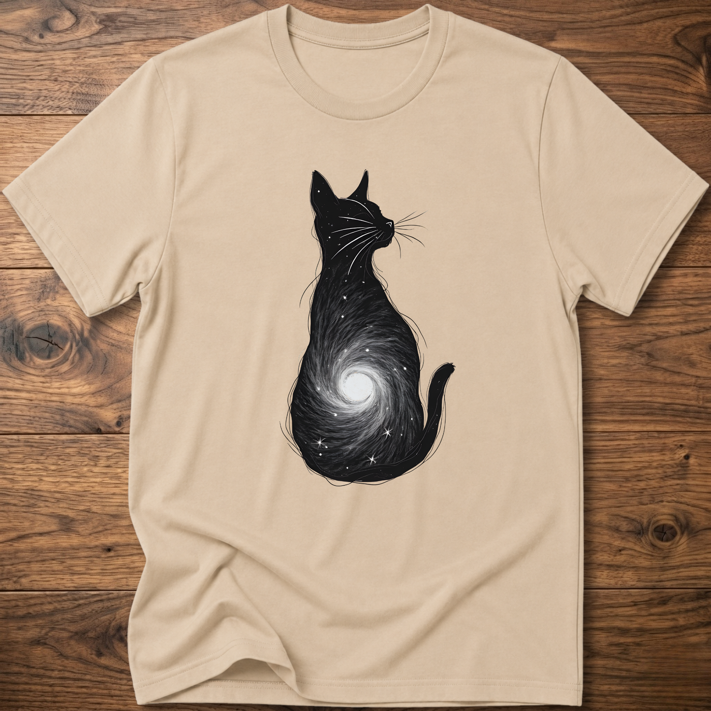 Beige cat graphic t-shirt with black cat silhouette and spiral galaxy swirl on front