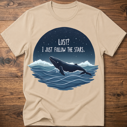 Sand whale graphic t-shirt with circular “LOST? I JUST FOLLOW THE STARS.” print
