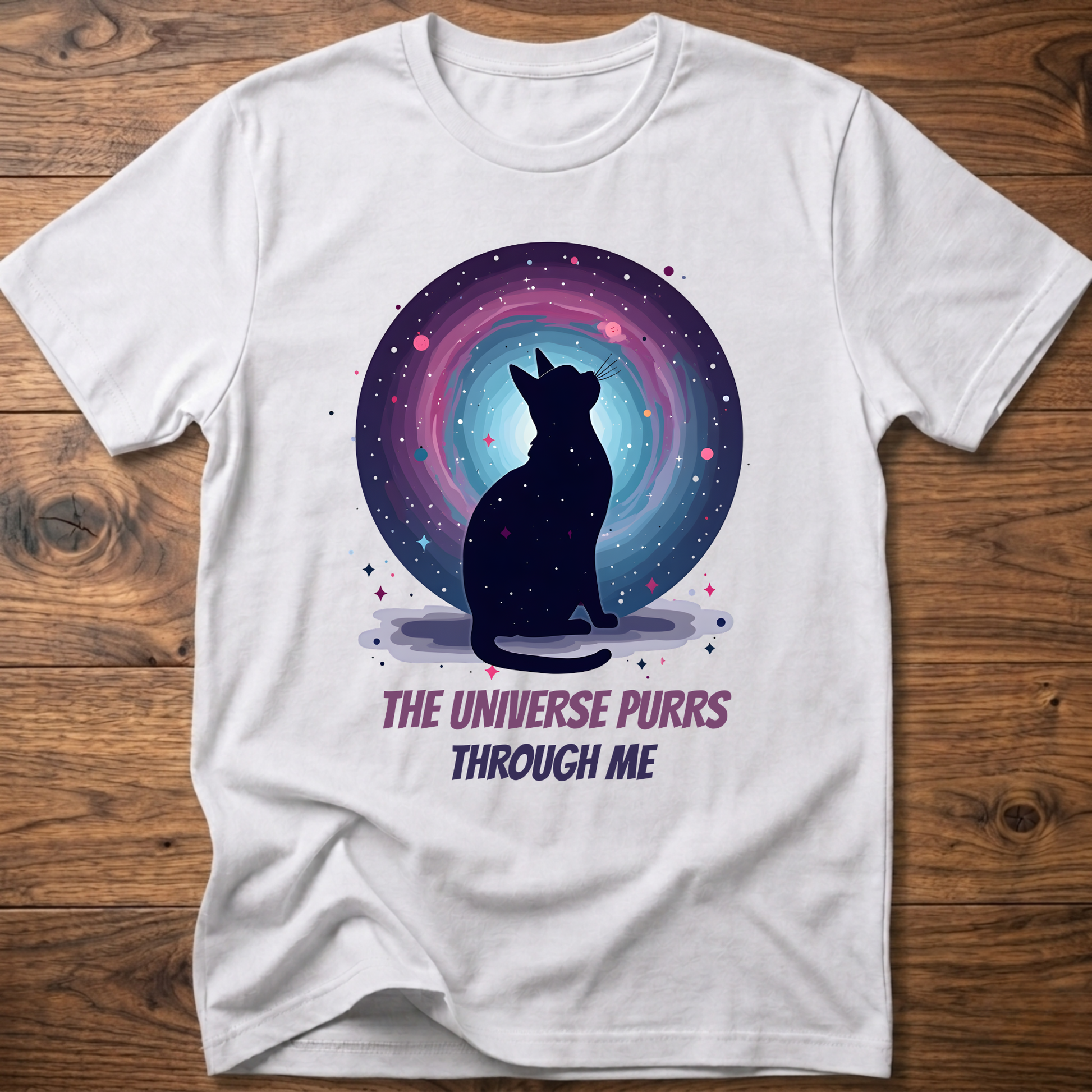 White cat t-shirt with cosmic cat silhouette and purple "The universe purrs through me" text