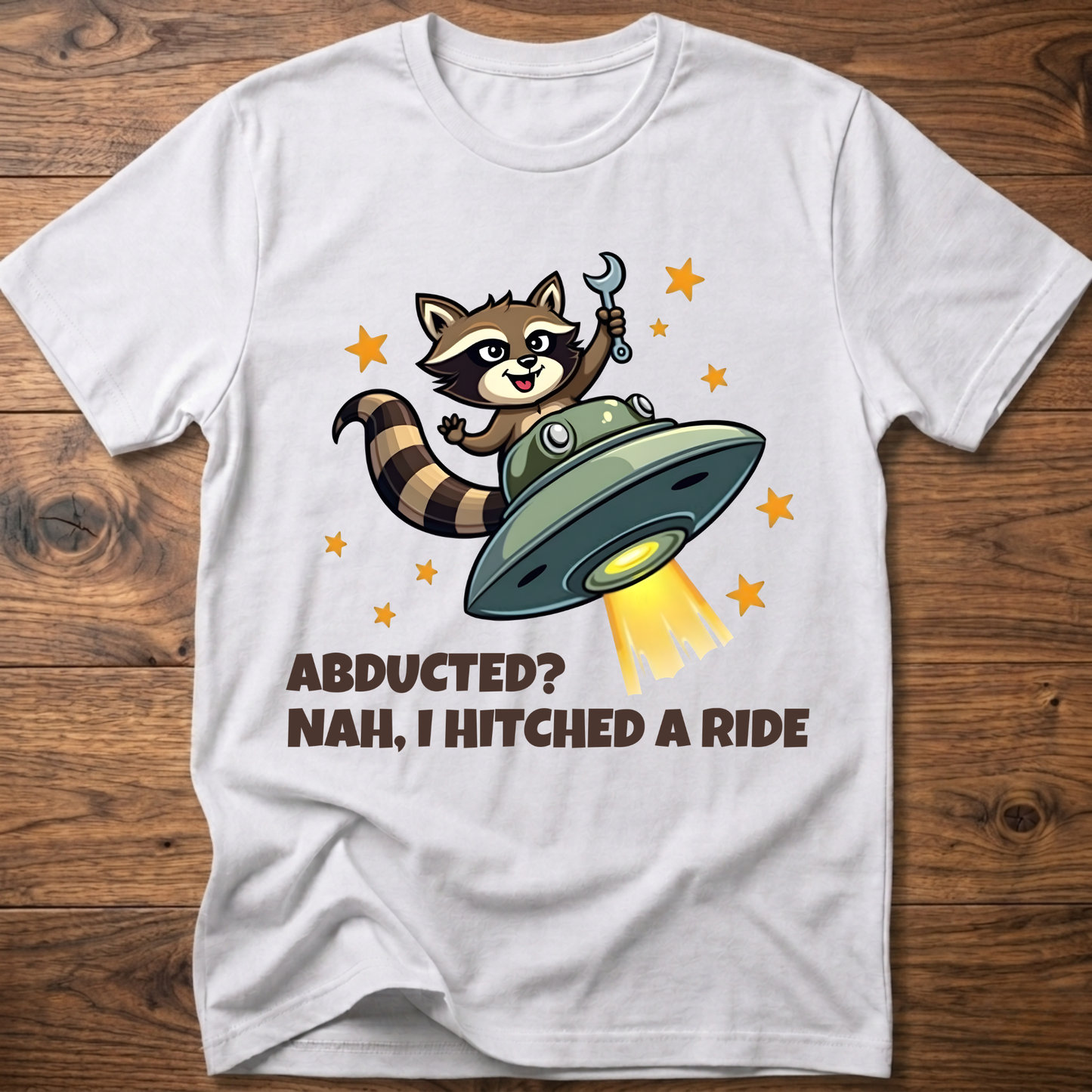 White raccoon UFO graphic T-shirt with 'ABDUCTED?' and 'HITCHED A RIDE' text