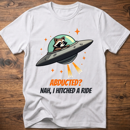 White raccoon graphic t-shirt with UFO and orange "ABDUCTED?" text